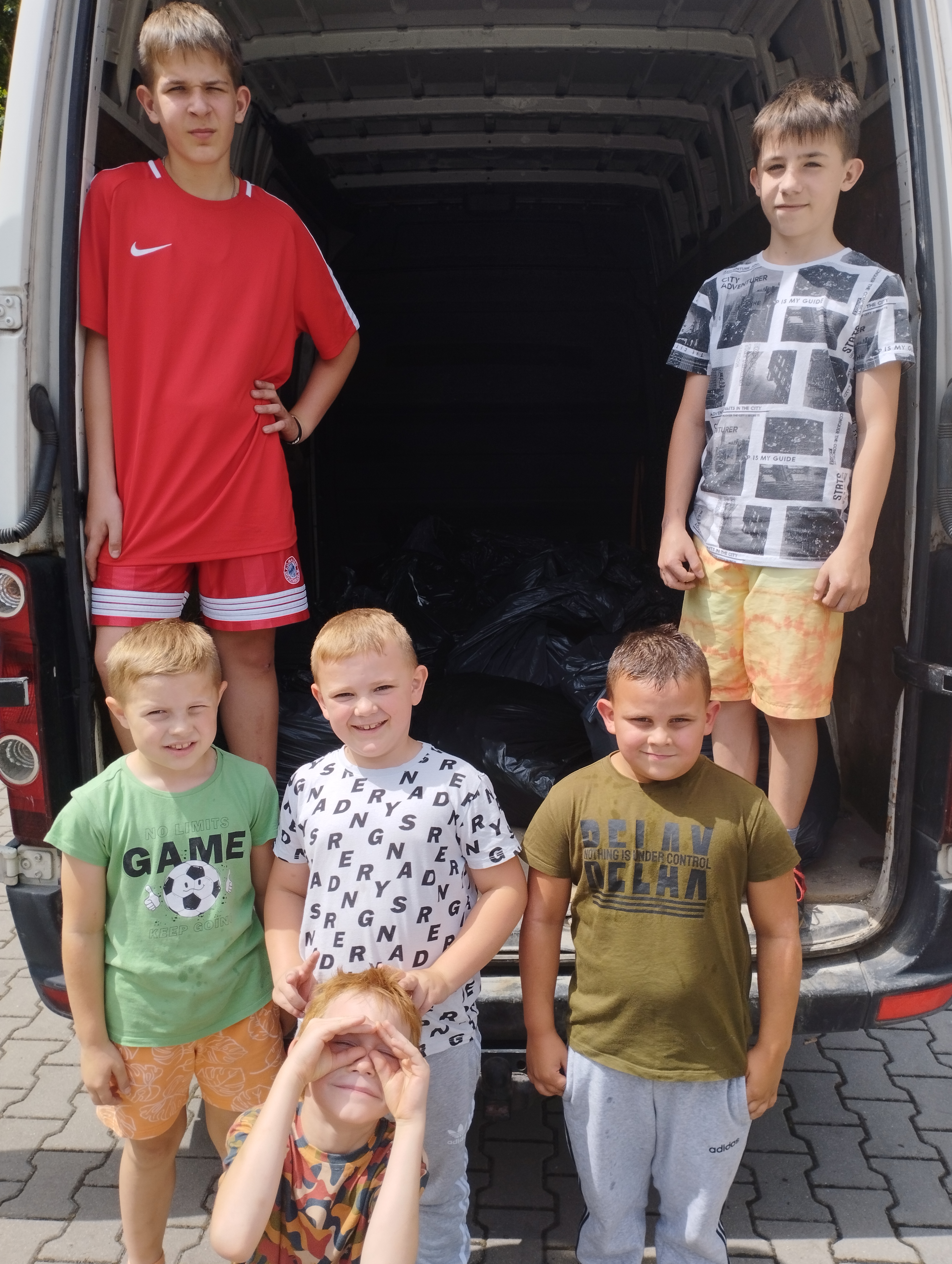 Uczniowie szkoły w trakcie ładunku nakrętek do samochodu.