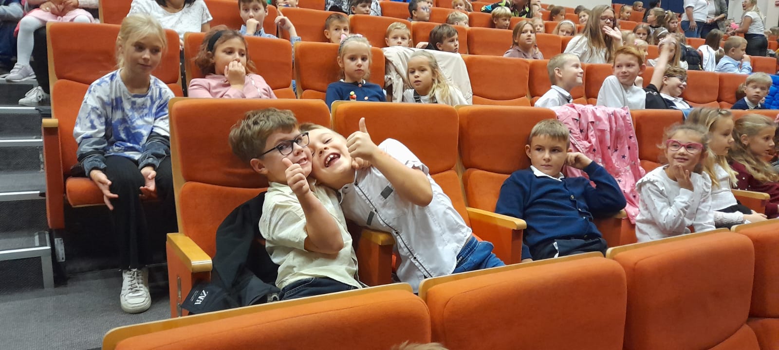 Dwaj chłopcy pokazują kciuki do góry w geście zadowolenia