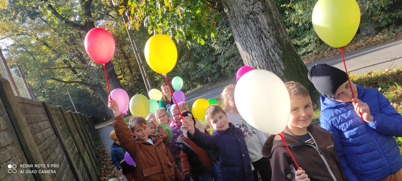 Dzieci trzymają kolorowe balony.