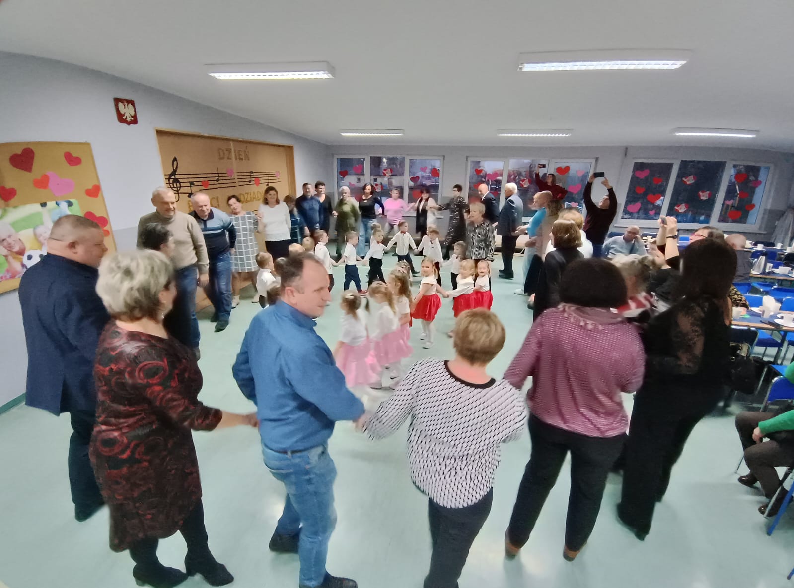 Dzieci bawią się wspólnie z dziadkami w kole.